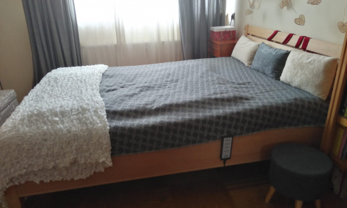 französisches Bett, frisch bezogen, großes Fenster mit Store und Vorhang